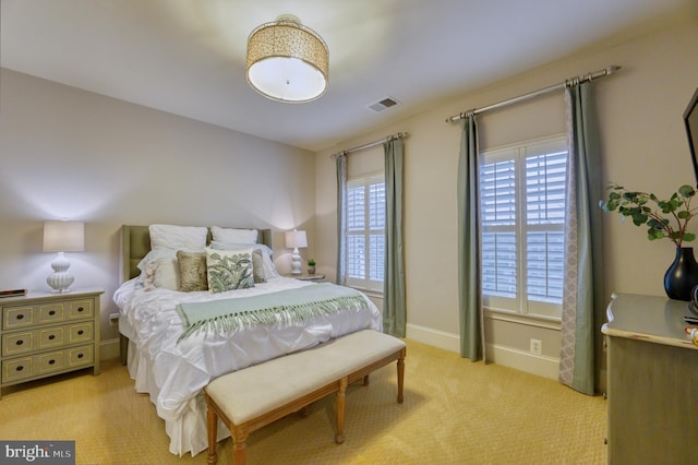 bedroom featuring light colored carpet and multiple windows