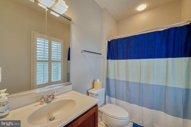 bathroom with a shower with curtain, vanity, and toilet