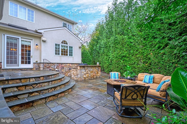 view of patio / terrace with an outdoor living space with a fire pit