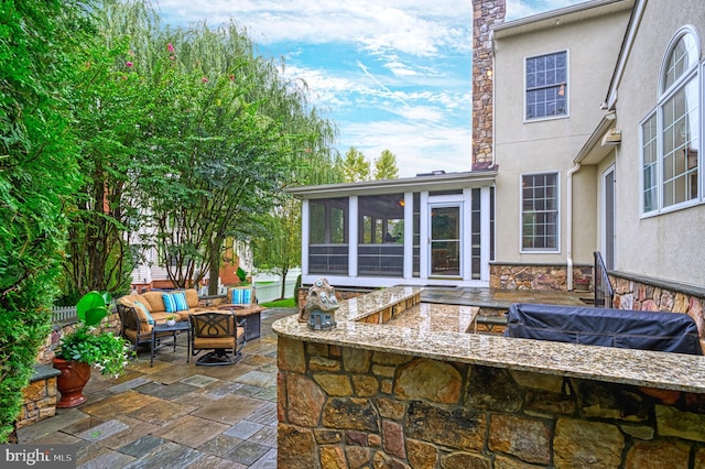 view of patio / terrace with a sunroom and a fire pit