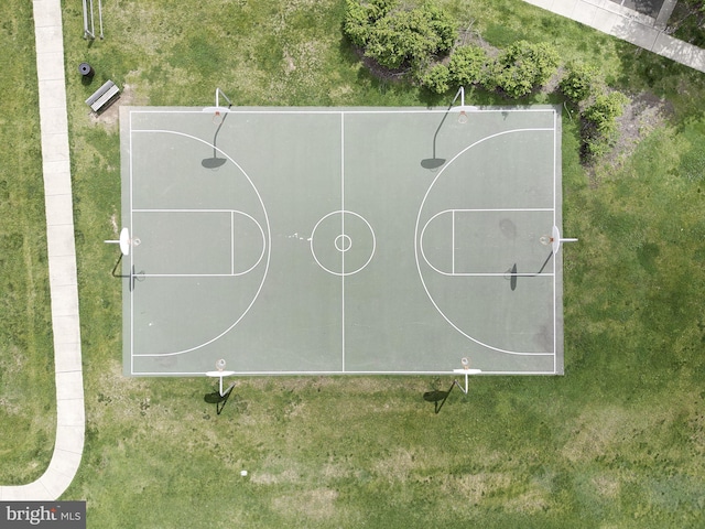 view of basketball court with a yard