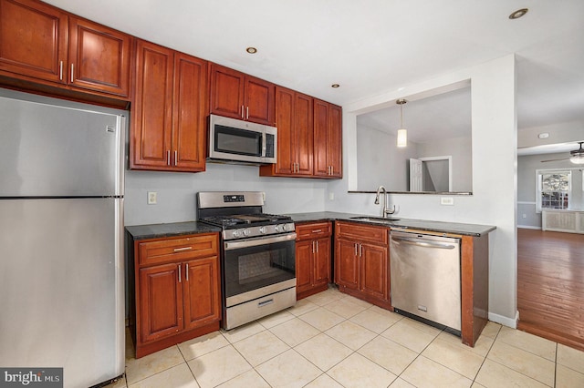 kitchen featuring decorative light fixtures, sink, light tile patterned floors, ceiling fan, and stainless steel appliances