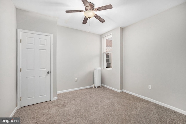 empty room featuring carpet, radiator, and ceiling fan