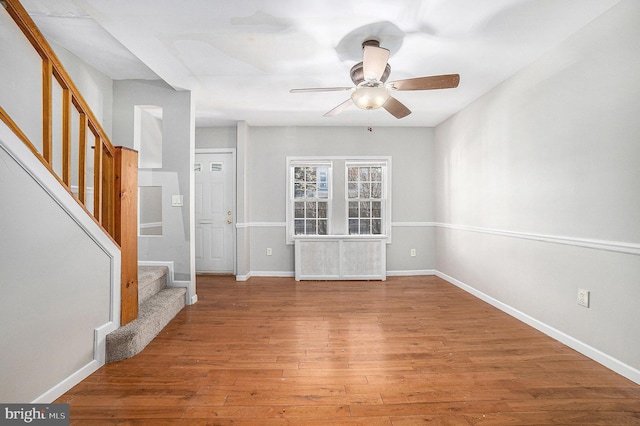 unfurnished living room with wood-type flooring and ceiling fan