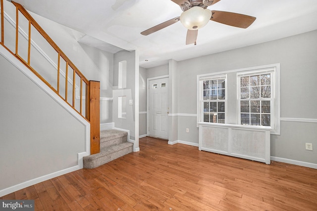 interior space with radiator heating unit, ceiling fan, and light hardwood / wood-style flooring