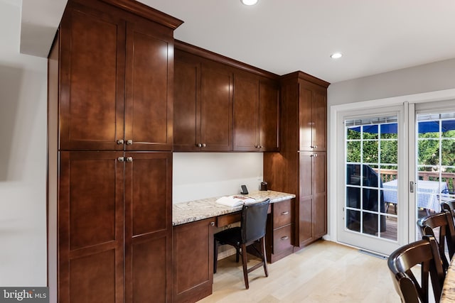 office space featuring built in desk and light wood-type flooring