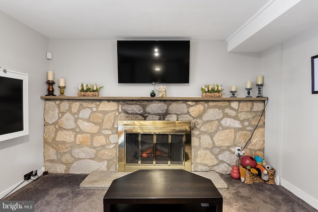 living room with a stone fireplace and carpet floors