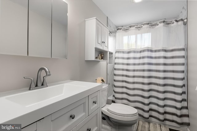 bathroom featuring walk in shower, vanity, and toilet