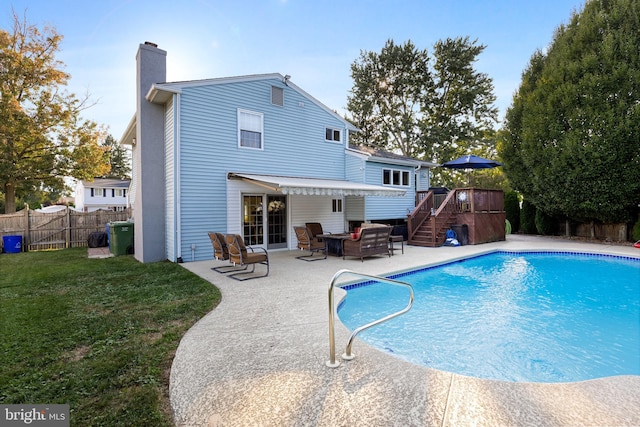 back of property with a pool side deck, an outdoor hangout area, a patio area, and a lawn