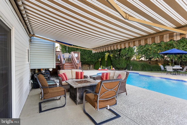 view of pool featuring an outdoor living space with a fire pit and a patio