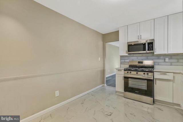 kitchen with backsplash, stainless steel appliances, and white cabinets