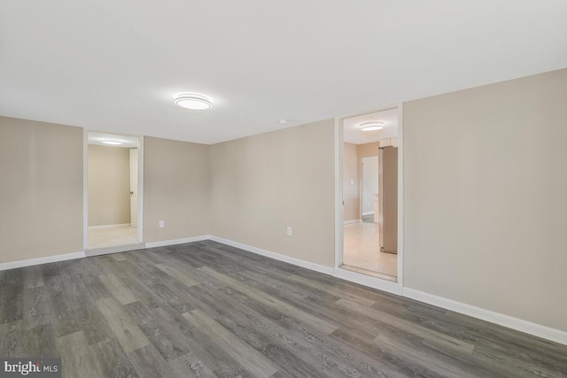 unfurnished room with dark hardwood / wood-style flooring