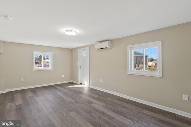 spare room featuring dark hardwood / wood-style flooring and an AC wall unit