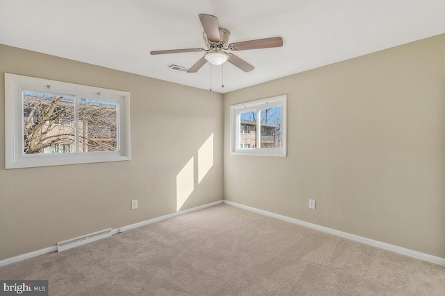 carpeted spare room featuring ceiling fan