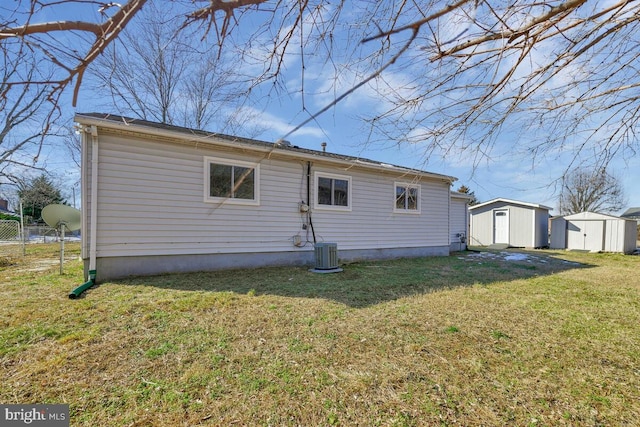 rear view of property featuring a yard, central air condition unit, and a shed