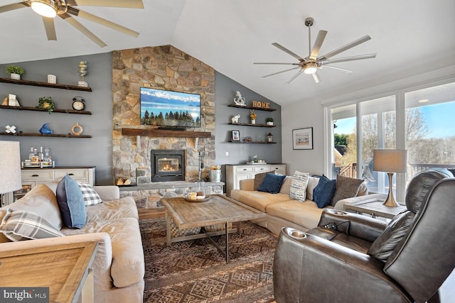 living room with ceiling fan, lofted ceiling, and a fireplace