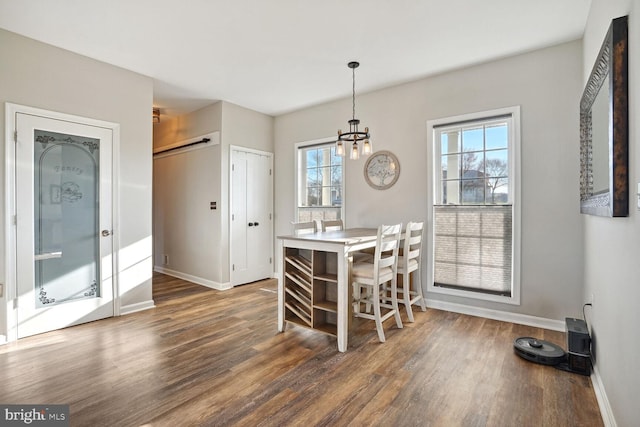 dining room with dark hardwood / wood-style flooring and a chandelier