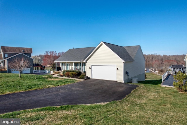 view of front facade featuring a garage, covered porch, and a front lawn