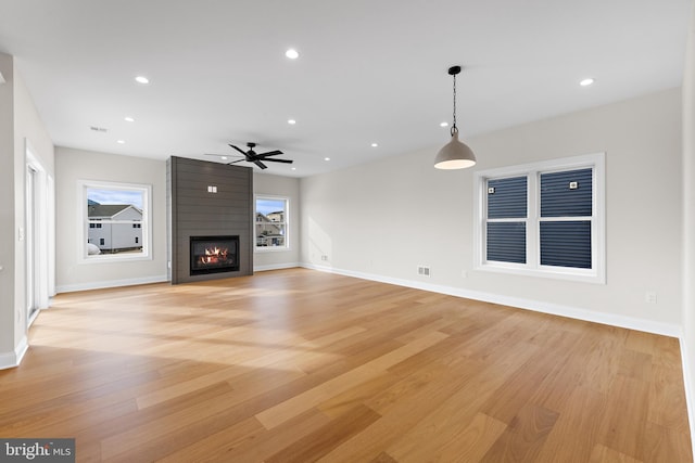 unfurnished living room with recessed lighting, a fireplace, baseboards, and light wood-style floors