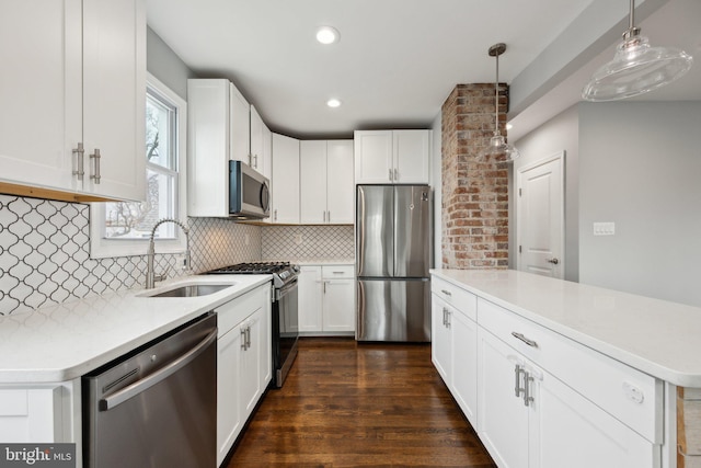 kitchen with white cabinetry, appliances with stainless steel finishes, decorative backsplash, decorative light fixtures, and sink