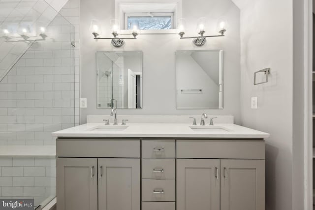 bathroom featuring a shower with shower door and vanity