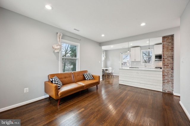 living area with a wealth of natural light and dark hardwood / wood-style floors