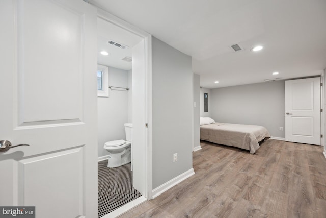 bedroom featuring light wood-type flooring and connected bathroom