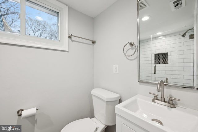 bathroom featuring toilet, vanity, and an enclosed shower