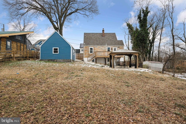 rear view of house with a lawn, a gazebo, a storage unit, and a patio