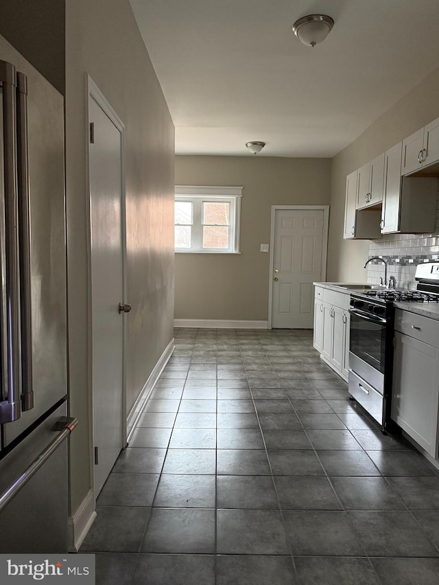 kitchen featuring backsplash, sink, white cabinets, and stainless steel appliances