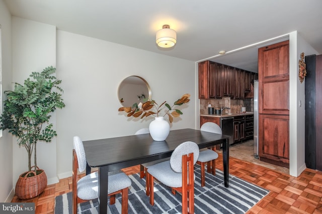 dining area with sink and light parquet flooring