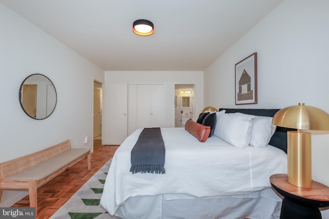 bedroom featuring ensuite bathroom, a closet, and parquet floors