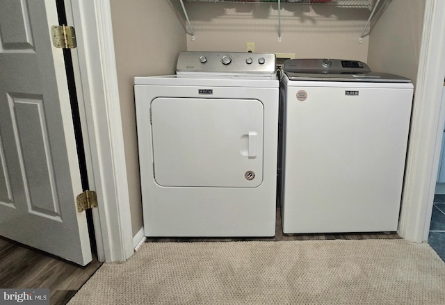 clothes washing area featuring laundry area, independent washer and dryer, and wood finished floors