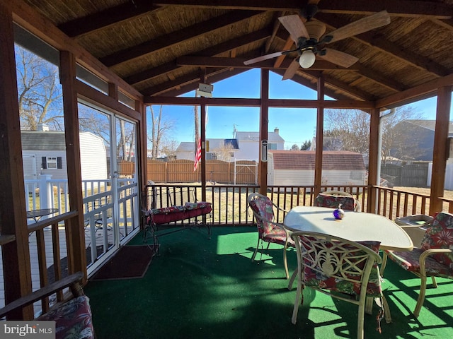 sunroom / solarium with vaulted ceiling with beams, wood ceiling, and a ceiling fan