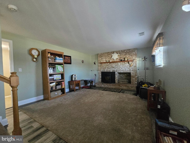 living room with visible vents, a fireplace, baseboards, and stairs