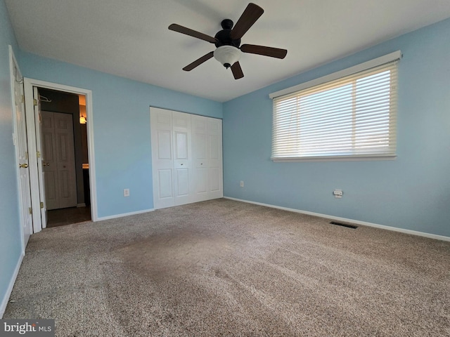 unfurnished bedroom with visible vents, baseboards, ensuite bathroom, carpet floors, and a closet