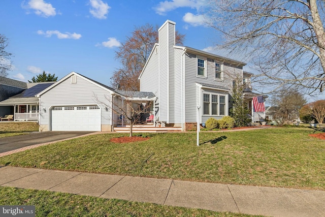 view of front facade with an attached garage, driveway, a chimney, and a front lawn