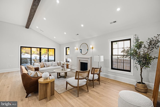 living room with high vaulted ceiling, light wood-type flooring, a healthy amount of sunlight, and beam ceiling