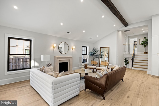 living room with light hardwood / wood-style flooring and vaulted ceiling with beams