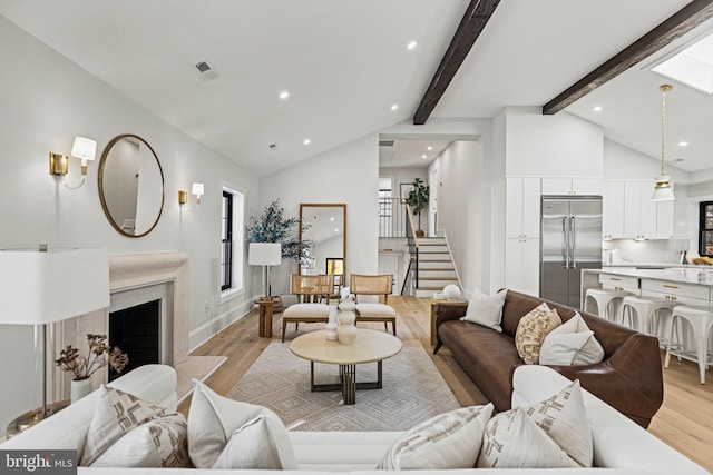 living room featuring light hardwood / wood-style floors and vaulted ceiling with beams