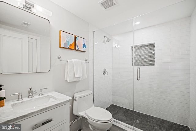 bathroom with toilet, a shower with door, and vanity