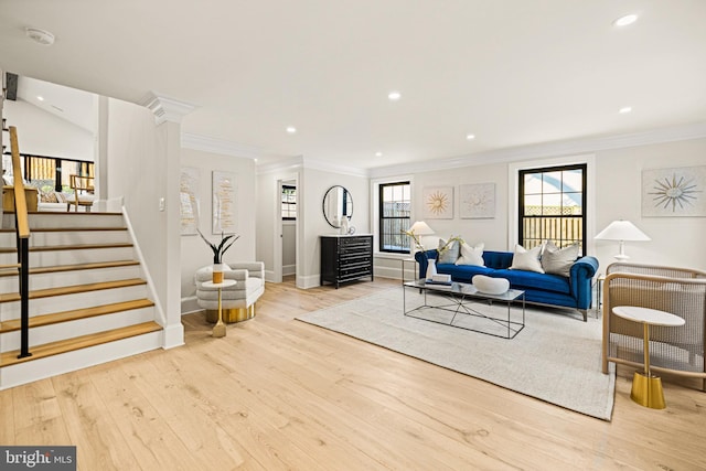 living room with light hardwood / wood-style floors and crown molding