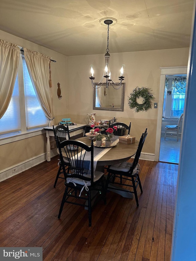 dining room with dark hardwood / wood-style flooring and a chandelier