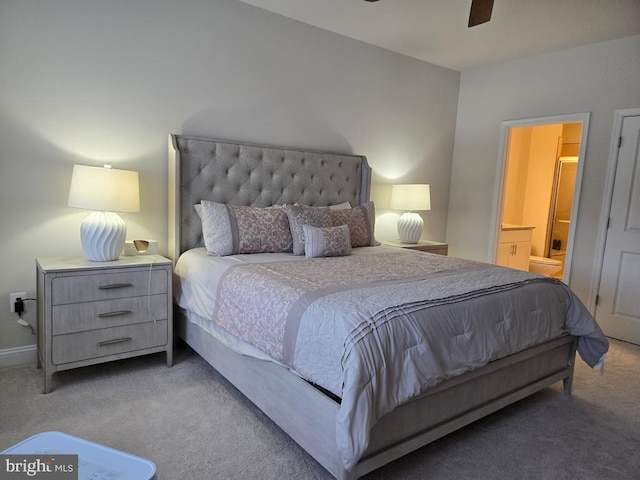 bedroom featuring ceiling fan, ensuite bathroom, and light colored carpet