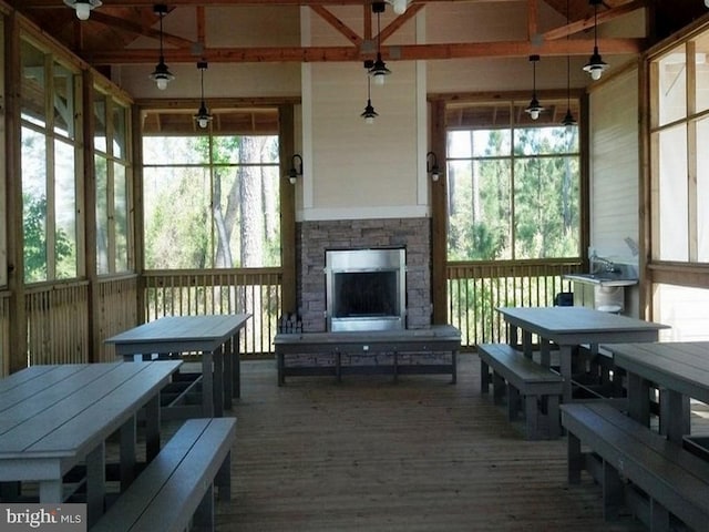 sunroom / solarium featuring an outdoor stone fireplace