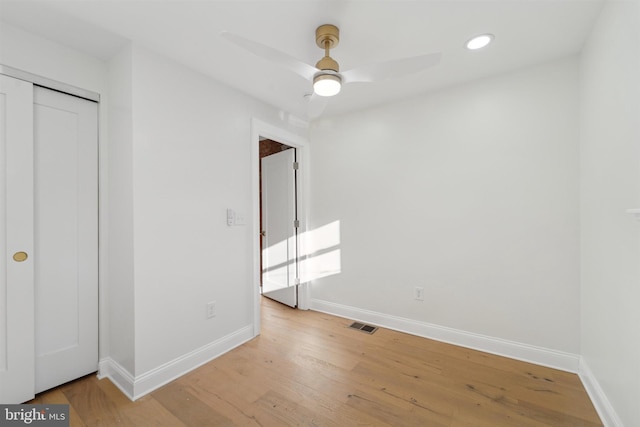 unfurnished bedroom featuring light wood-type flooring, a closet, and ceiling fan