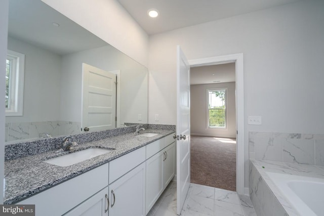 bathroom featuring vanity and a relaxing tiled tub