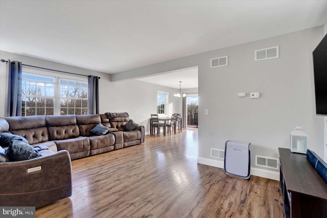 living room featuring hardwood / wood-style floors, an inviting chandelier, and a wealth of natural light