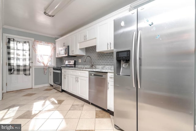 kitchen with crown molding, light tile patterned floors, appliances with stainless steel finishes, decorative backsplash, and white cabinets