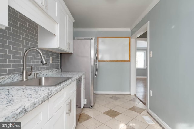 kitchen featuring sink, white cabinetry, light stone counters, ornamental molding, and decorative backsplash